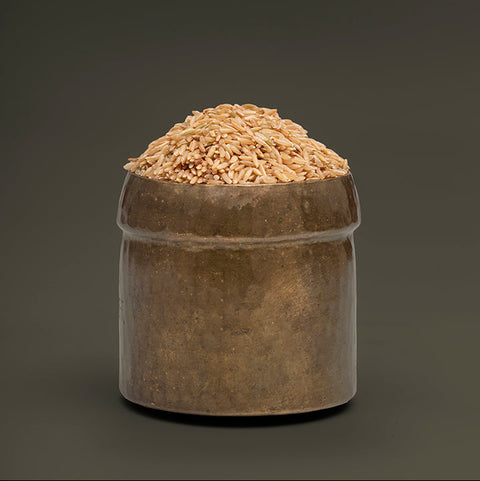 Ceramic container filled with grain on a dark background