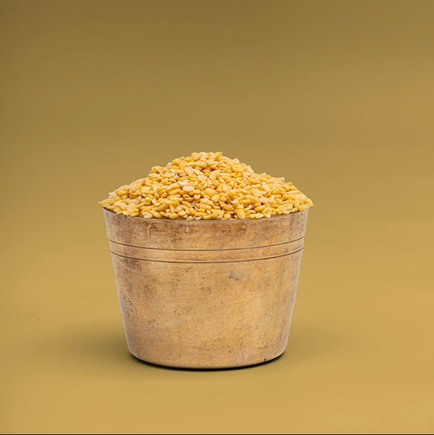 Wooden bucket filled with yellow grains on a beige background