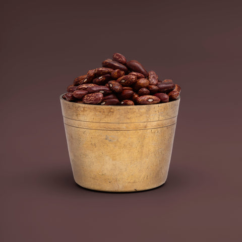 Wooden bucket filled with red beans on a brown background