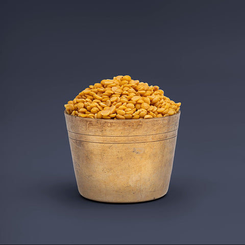 Wooden bowl filled with yellow beans on a dark background